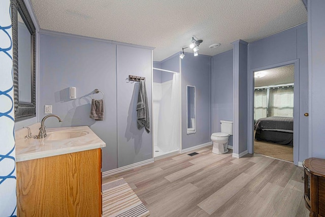 50031 E County Rd 71, Midland, TX 79705 - bathroom featuring wood finished floors, toilet, a textured ceiling, vanity, and a shower with curtain