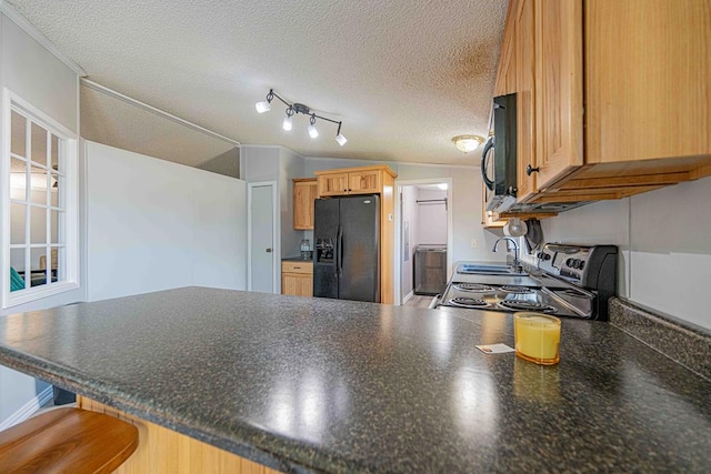 50031 E County Rd 71, Midland, TX 79705 - kitchen featuring black appliances, a peninsula, a sink, dark countertops, and a textured ceiling