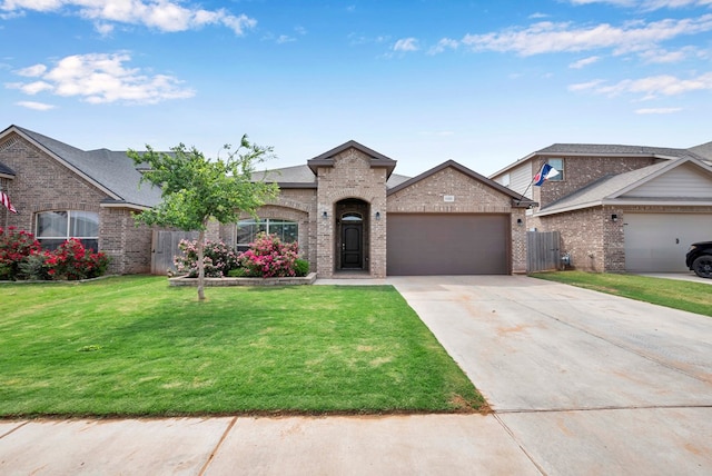 view of front of home with concrete driveway, a front lawn, brick siding, a garage, and fence