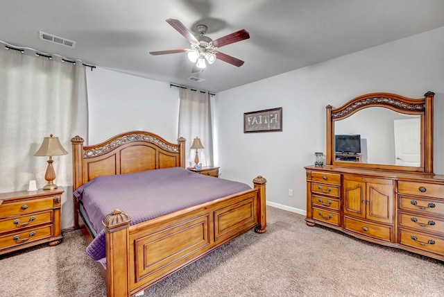 bedroom featuring light carpet, visible vents, baseboards, and ceiling fan