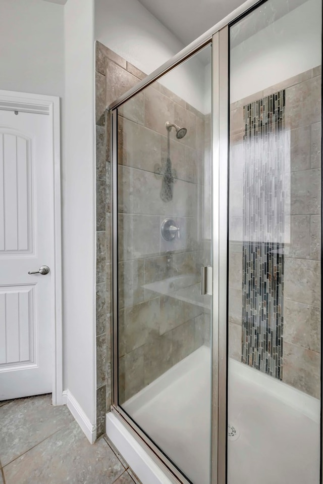 bathroom featuring baseboards and a shower stall