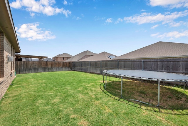 view of yard featuring a fenced backyard and a trampoline