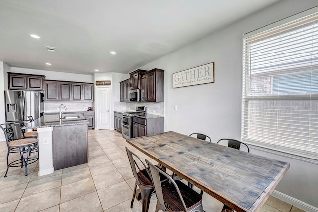 dining space featuring light tile patterned floors, baseboards, and recessed lighting