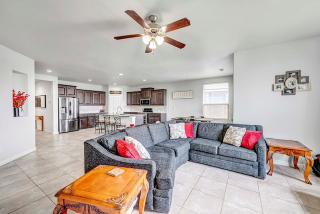 living area featuring light tile patterned floors, baseboards, a ceiling fan, and recessed lighting