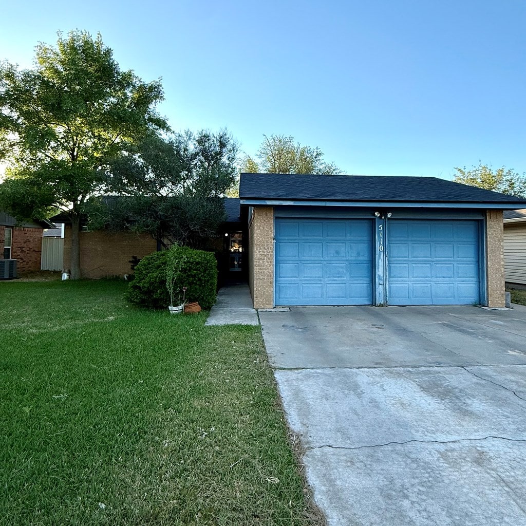 garage featuring concrete driveway and central AC unit