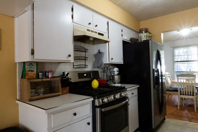 5110 Sunnyside Dr, Midland, TX 79703 - kitchen with gas range, under cabinet range hood, tasteful backsplash, white cabinetry, and a textured ceiling