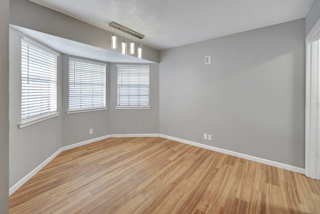 empty room featuring light hardwood / wood-style floors and a textured ceiling