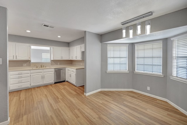 kitchen with dishwasher, light wood-type flooring, hanging light fixtures, and white cabinets