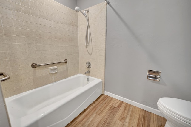 bathroom featuring hardwood / wood-style flooring, toilet, and tiled shower / bath combo