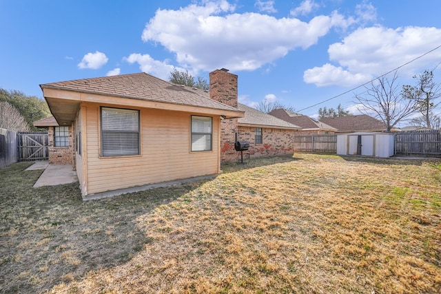 rear view of house with a lawn and a storage shed