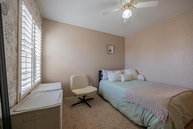 carpeted bedroom with a textured ceiling and ceiling fan