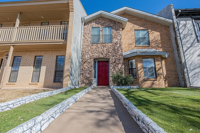 view of front of house featuring a front yard and a balcony