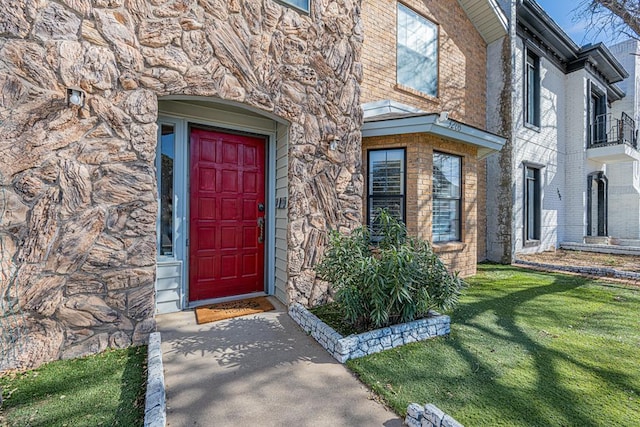 view of exterior entry with a yard