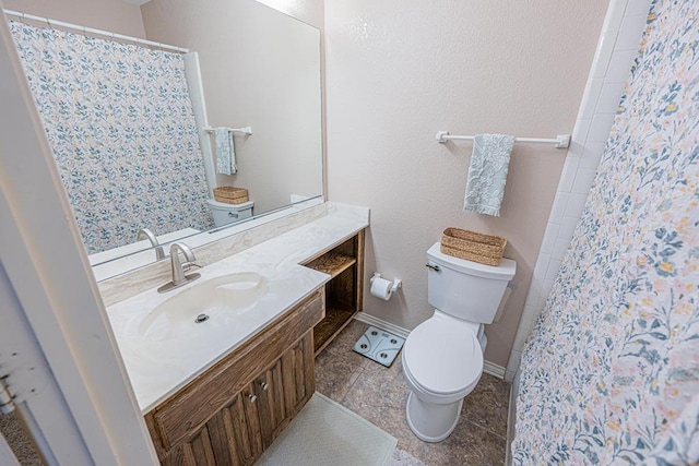 bathroom featuring toilet, tile patterned floors, vanity, and walk in shower