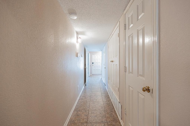 hall featuring a textured ceiling