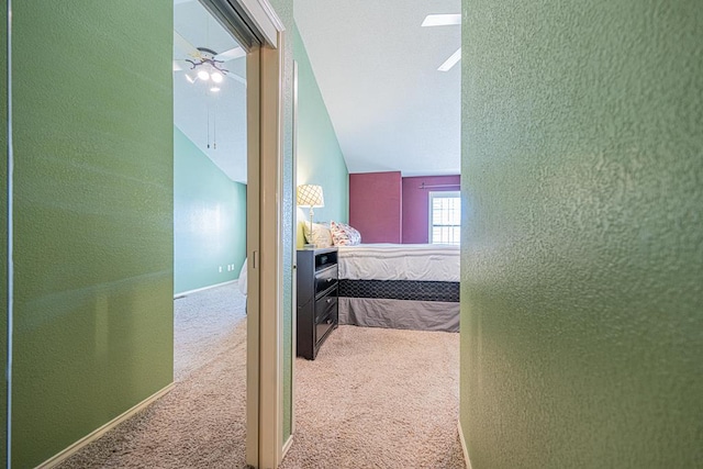 hallway with vaulted ceiling and carpet floors