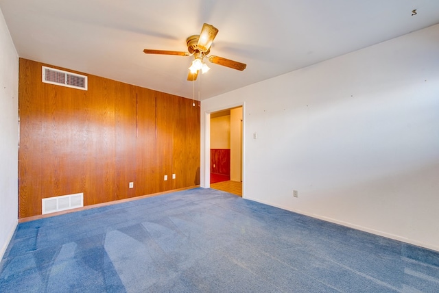 4717 W Illinois Ave, Midland, TX 79703 - carpeted spare room featuring ceiling fan, wooden walls, and baseboards