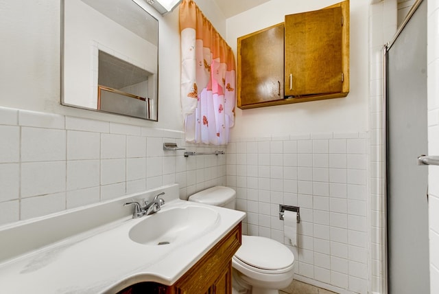 4717 W Illinois Ave, Midland, TX 79703 - bathroom featuring toilet, a shower with door, tile walls, vanity, and wainscoting