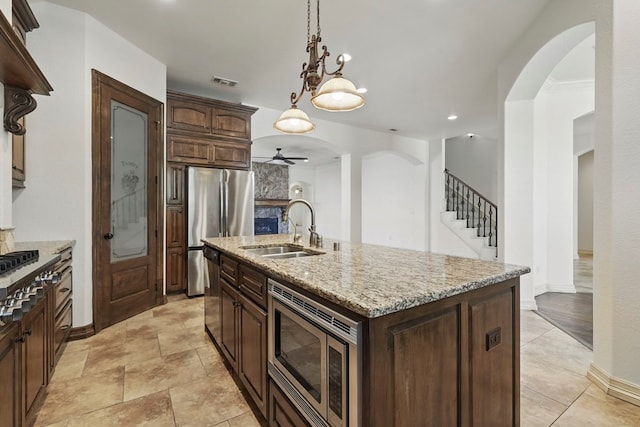5001 Crista Ln, Midland, TX 79707 - kitchen featuring stainless steel appliances, a sink, a ceiling fan, arched walkways, and recessed lighting
