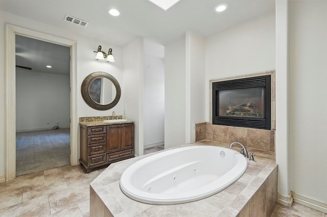 5001 Crista Ln, Midland, TX 79707 - full bath with vanity, a tub with jets, a fireplace, recessed lighting, and baseboards