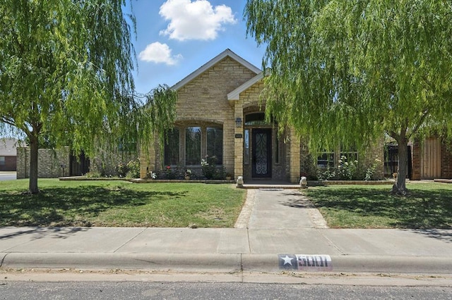 5001 Crista Ln, Midland, TX 79707 - view of property hidden behind natural elements featuring stone siding and a front lawn