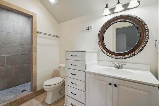 5001 Crista Ln, Midland, TX 79707 - bathroom featuring lofted ceiling, toilet, vanity, a tile shower, and tile patterned flooring