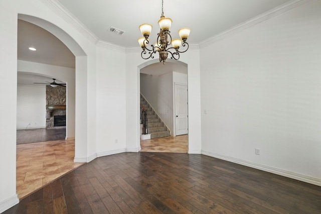 5001 Crista Ln, Midland, TX 79707 - unfurnished room featuring hardwood / wood-style flooring, arched walkways, a chandelier, a fireplace, and stairway