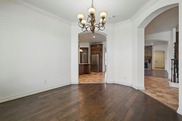 5001 Crista Ln, Midland, TX 79707 - unfurnished dining area with wood-type flooring, a chandelier, crown molding, a fireplace, and baseboards
