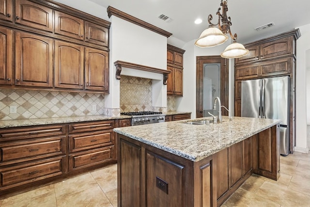 5001 Crista Ln, Midland, TX 79707 - kitchen with freestanding refrigerator, a sink, light stone countertops, tasteful backsplash, and hanging light fixtures