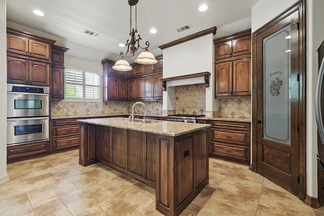 5001 Crista Ln, Midland, TX 79707 - kitchen with double oven, a sink, a center island with sink, decorative backsplash, and recessed lighting