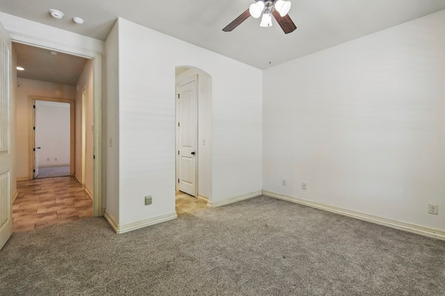 5001 Crista Ln, Midland, TX 79707 - unfurnished bedroom featuring arched walkways, carpet floors, baseboards, and a ceiling fan