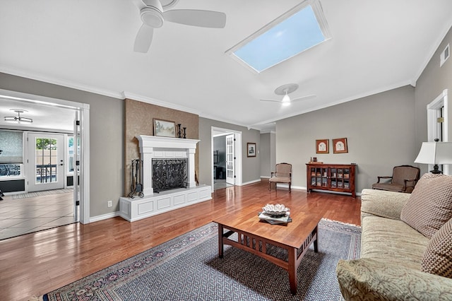 2409 Stutz Pl, Midland, TX 79705 - living room with ceiling fan, crown molding, wood finished floors, a skylight, and a fireplace