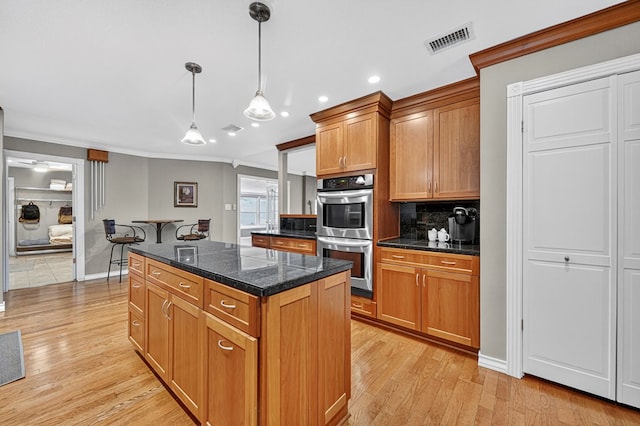2409 Stutz Pl, Midland, TX 79705 - kitchen with stainless steel double oven, ornamental molding, tile counters, a kitchen island, and backsplash
