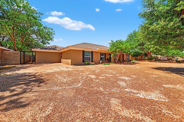 2409 Stutz Pl, Midland, TX 79705 - back of house featuring curved driveway, a gate, stucco siding, and brick siding
