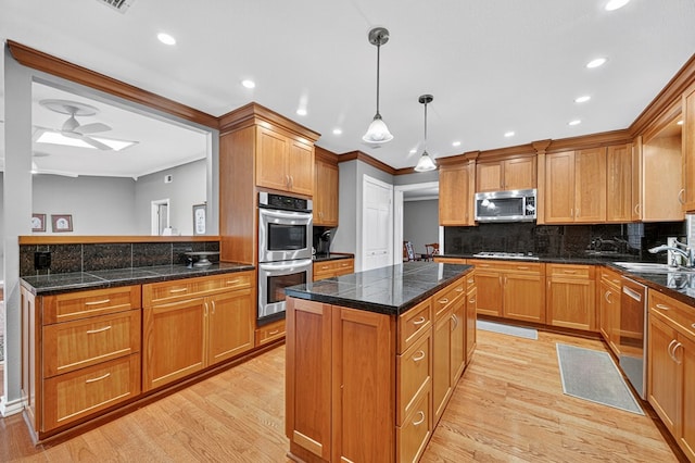 2409 Stutz Pl, Midland, TX 79705 - kitchen with stainless steel appliances, light wood-style flooring, a center island, backsplash, and ornamental molding