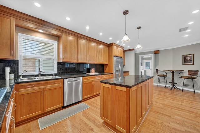 2409 Stutz Pl, Midland, TX 79705 - kitchen with stainless steel appliances, crown molding, tasteful backsplash, a kitchen island, and light wood-style floors