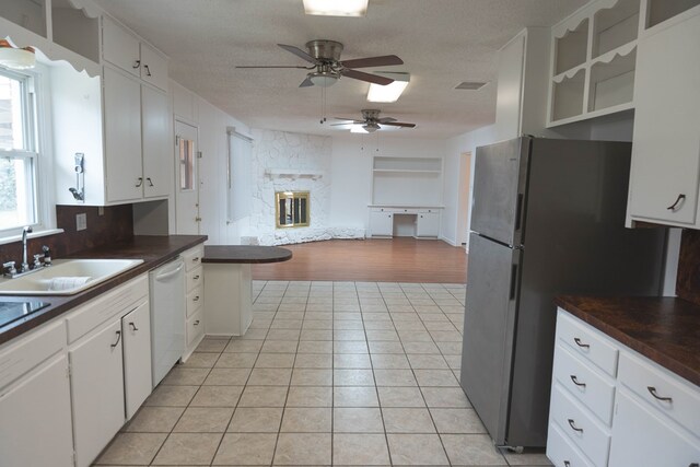 kitchen with light wood-type flooring, white dishwasher, white cabinetry, and ceiling fan