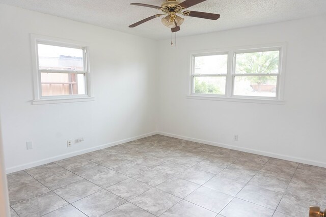 tiled spare room with ceiling fan and a textured ceiling