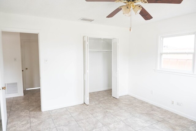 unfurnished bedroom featuring ceiling fan, light tile patterned floors, and a closet