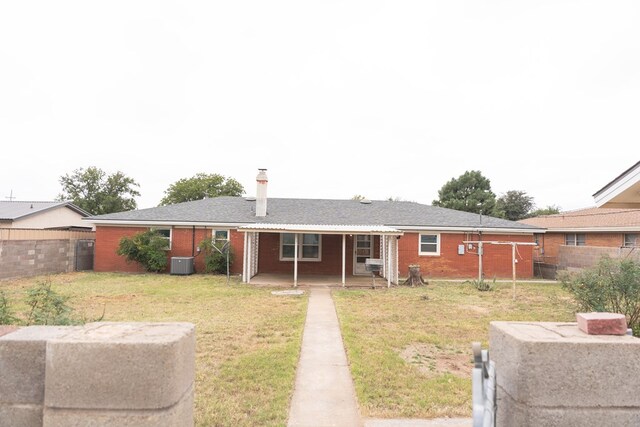 rear view of house with a yard and cooling unit