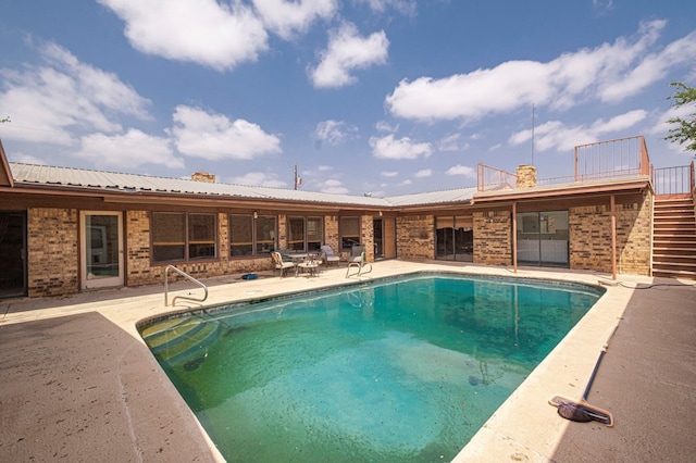 pool featuring stairs and a patio area