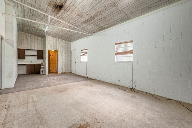 unfurnished living room featuring lofted ceiling and light carpet