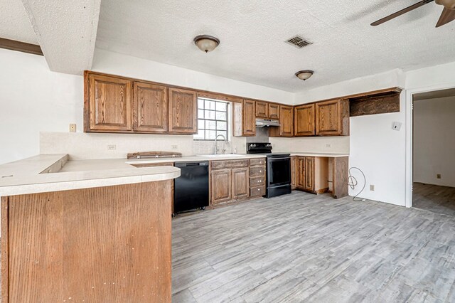 kitchen with a sink, under cabinet range hood, electric stove, black dishwasher, and a ceiling fan