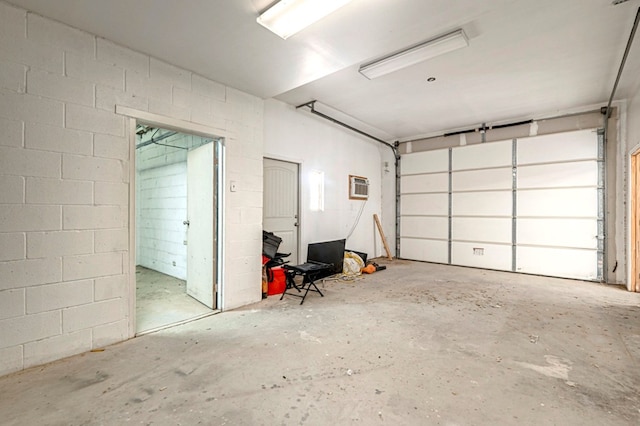 garage featuring concrete block wall and a wall unit AC