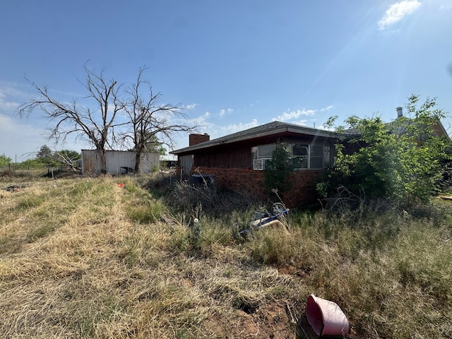 1516 E Old Colorado City Hwy, Big Spring, TX 79720 - view of side of home with a chimney and brick siding