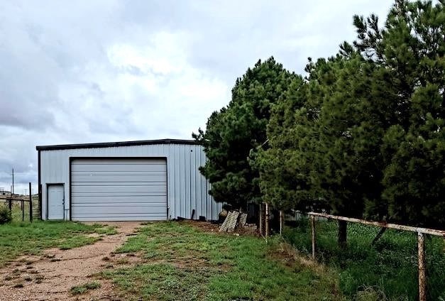 detached garage featuring fence