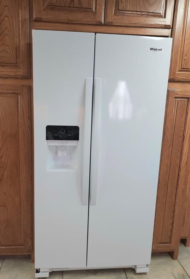 details featuring white fridge with ice dispenser and brown cabinets