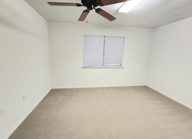 carpeted spare room with a textured ceiling and baseboards