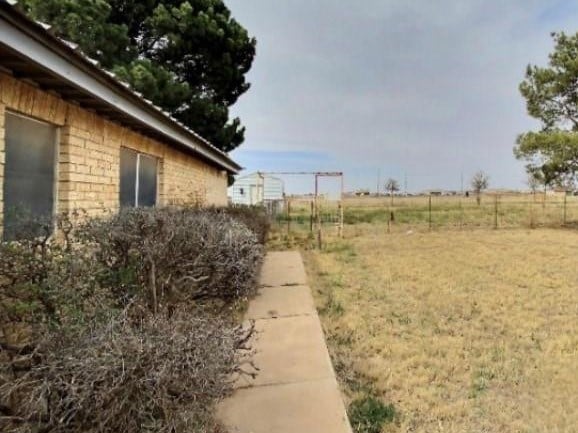 view of yard with a rural view and fence