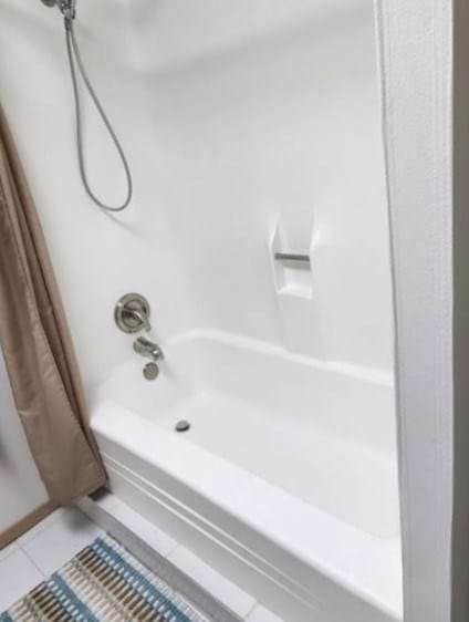 bathroom featuring shower / bathtub combination with curtain and tile patterned floors